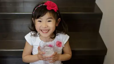 Child smiling with glass of water