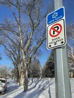 snow route no parking sign on street lamppost winter
