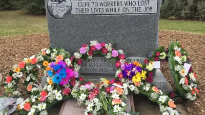 CUPE memorial headstone with flower wreaths