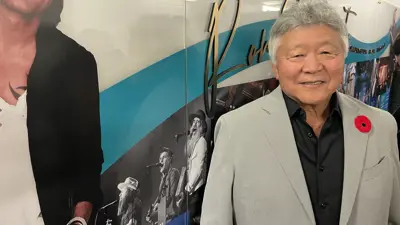 Ron Sakamoto beside Keith Urban poster